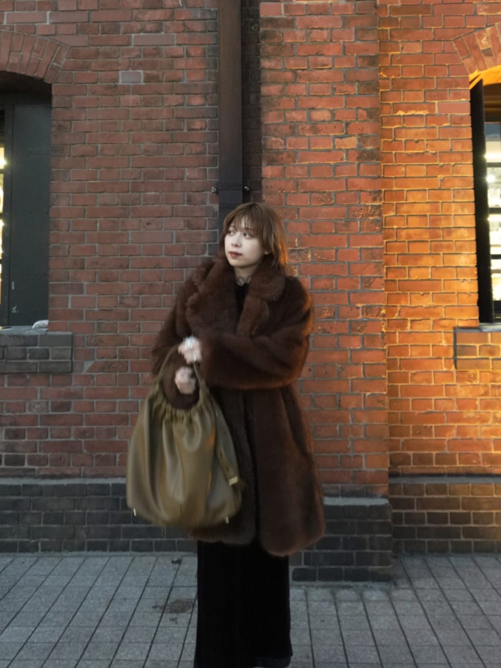 ブラウン系のジャケット/アウター、ブラック系のドレス、ブラウン系のバッグを着用したレディースの秋コーディネートの3枚目の写真