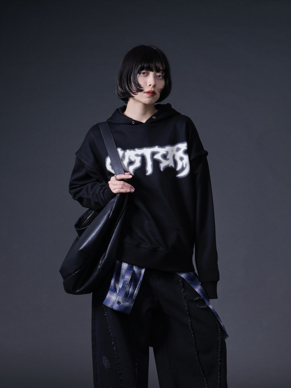 ブラック系のパーカー、ブラック系のデニムパンツを着用したレディースの冬コーディネートの2枚目の写真