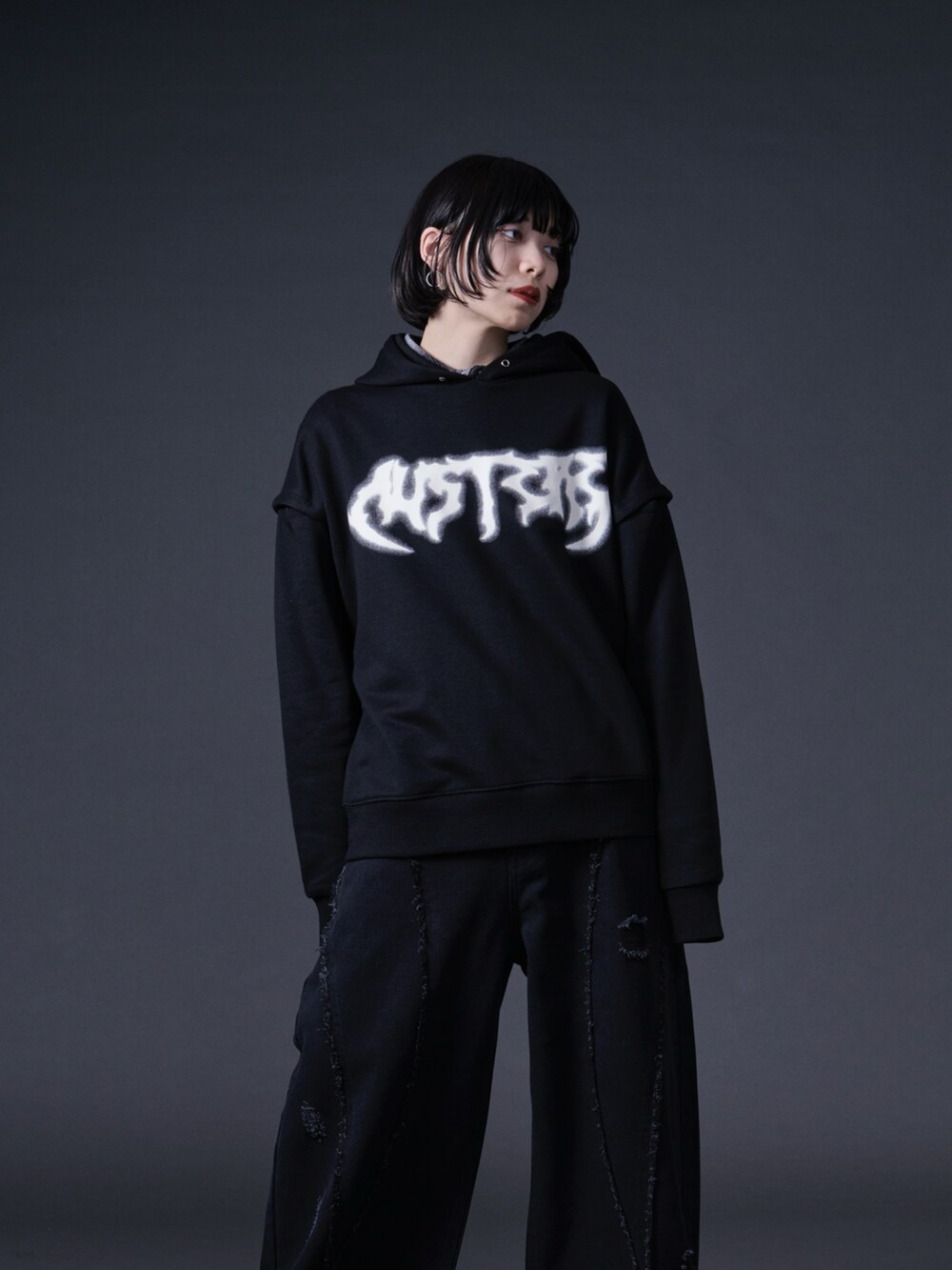 ブラック系のパーカー、ブラック系のデニムパンツを着用したレディースの冬コーディネートの4枚目の写真