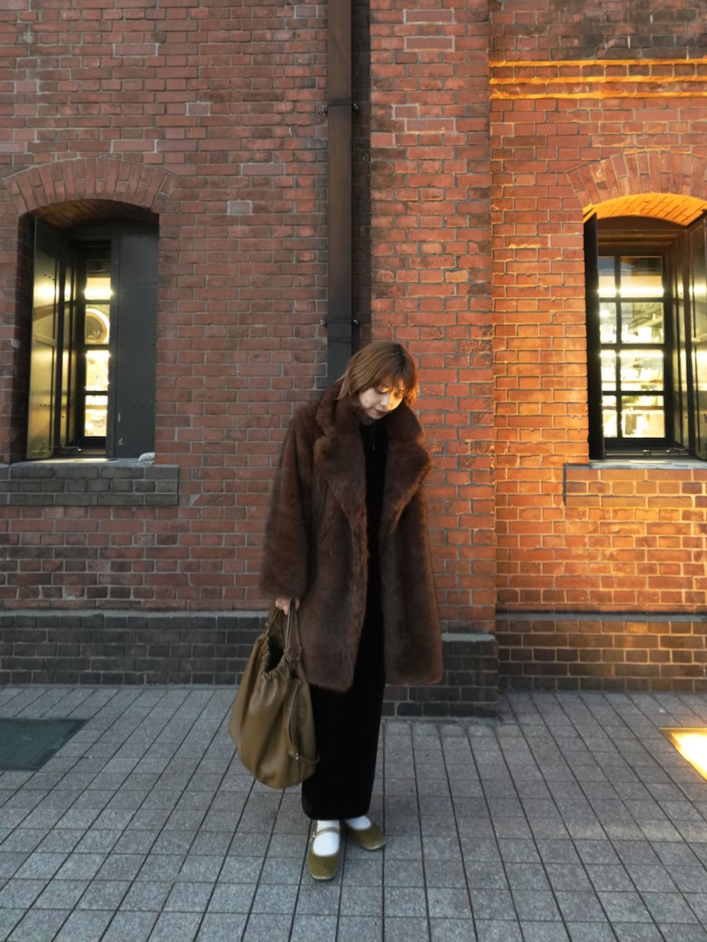 ブラウン系のジャケット/アウター、ブラック系のドレス、ブラウン系のバッグを着用したレディースの秋コーディネートの2枚目の写真