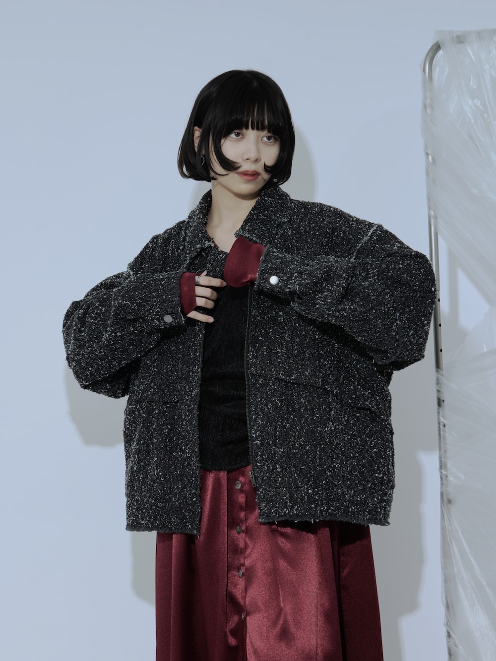 レッド系のワンピース、ブラック系のブーツ、ブラック系のデニムジャケットを着用したレディースの冬コーディネートの2枚目の写真