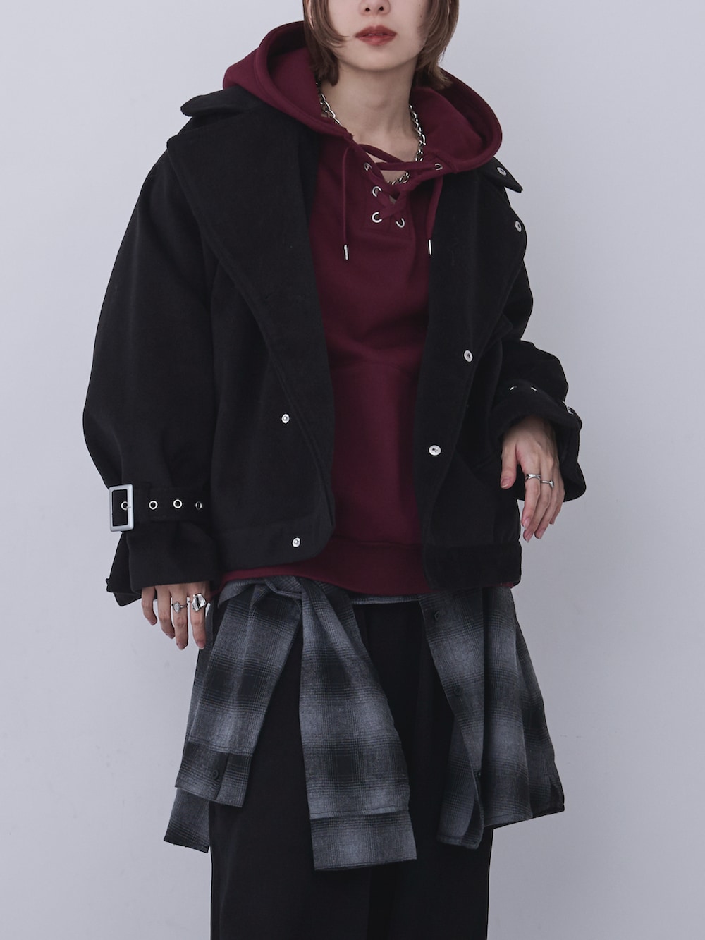 ブラック系のブルゾン、レッド系のパーカー、ブラック系のパンツを着用したレディースの冬コーディネートの2枚目の写真