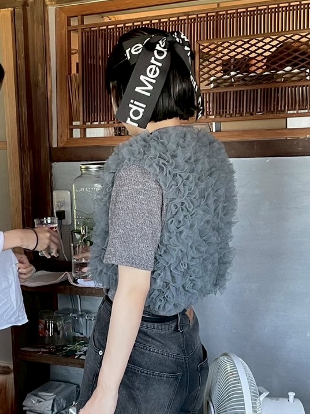 ブラック系のデニムパンツ、ブルー系のその他トップス、ブラック系のショルダーバッグを着用したレディースの夏コーディネートの3枚目の写真