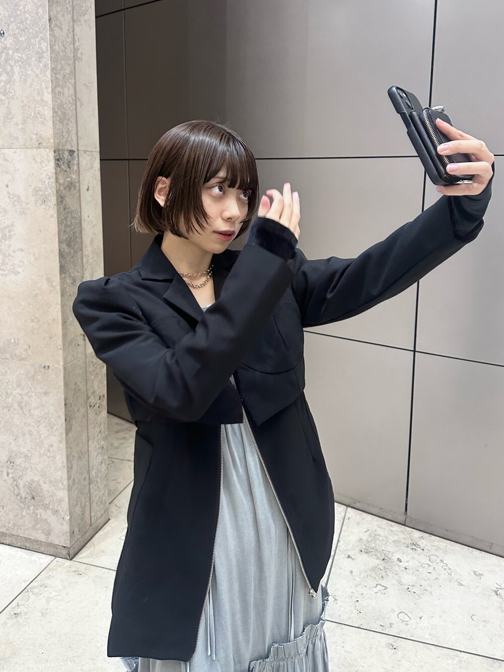 ブラック系のテーラードジャケット、ブラック系のワンピース、ホワイト系のその他を着用したレディースの冬コーディネートの3枚目の写真