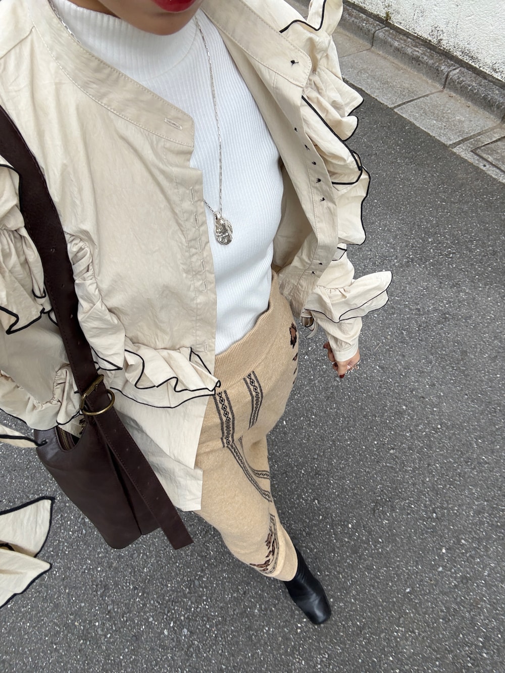 ホワイト系のトップス、ベージュ系のスカート、ブラウン系のトートバッグを着用したレディースの秋コーディネートの2枚目の写真