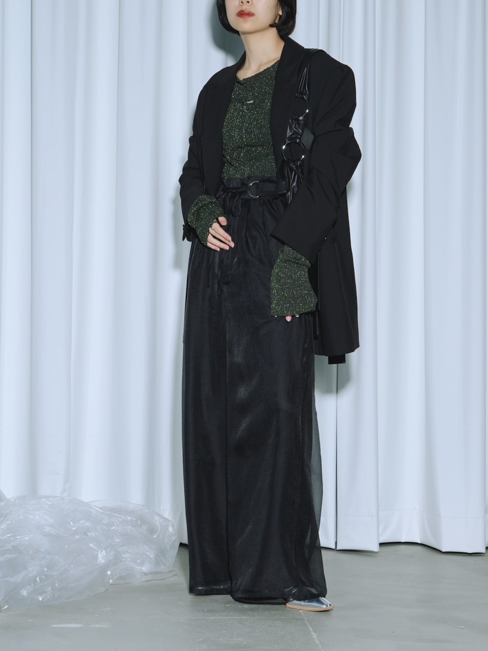 グリーン系のニット/セーター、ブラック系のテーラードジャケット、ブラック系のその他パンツを着用したレディースの春コーディネートの2枚目の写真