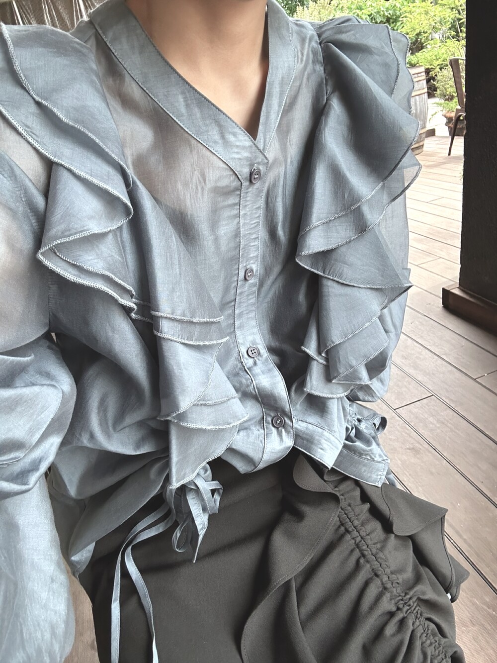 ブルー系のシャツ/ブラウス、ブラック系のスカート、ブラック系のパンプスを着用したレディースの春コーディネートの2枚目の写真