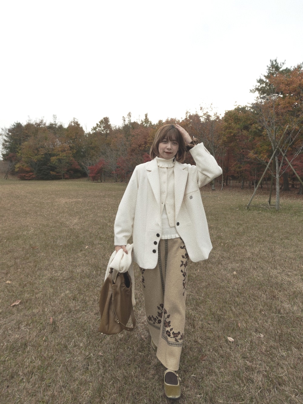 グリーン系のバレエシューズ、グレー系のニット/セーター、ホワイト系のジャケット/アウターを着用したレディースの秋コーディネートの3枚目の写真