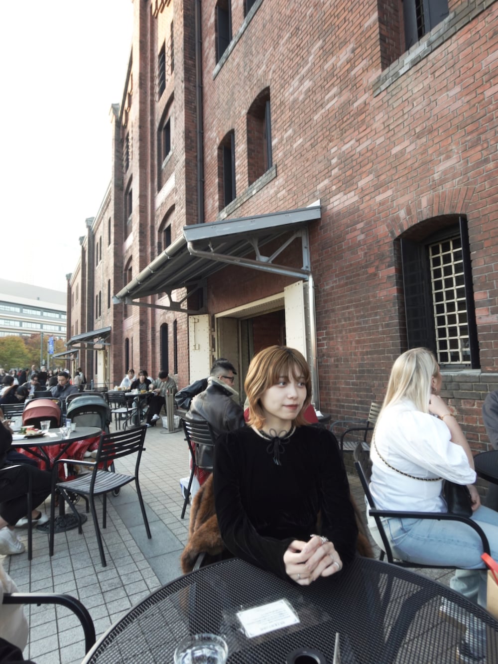 ブラウン系のジャケット/アウター、ブラック系のドレス、ブラウン系のバッグを着用したレディースの秋コーディネートの4枚目の写真