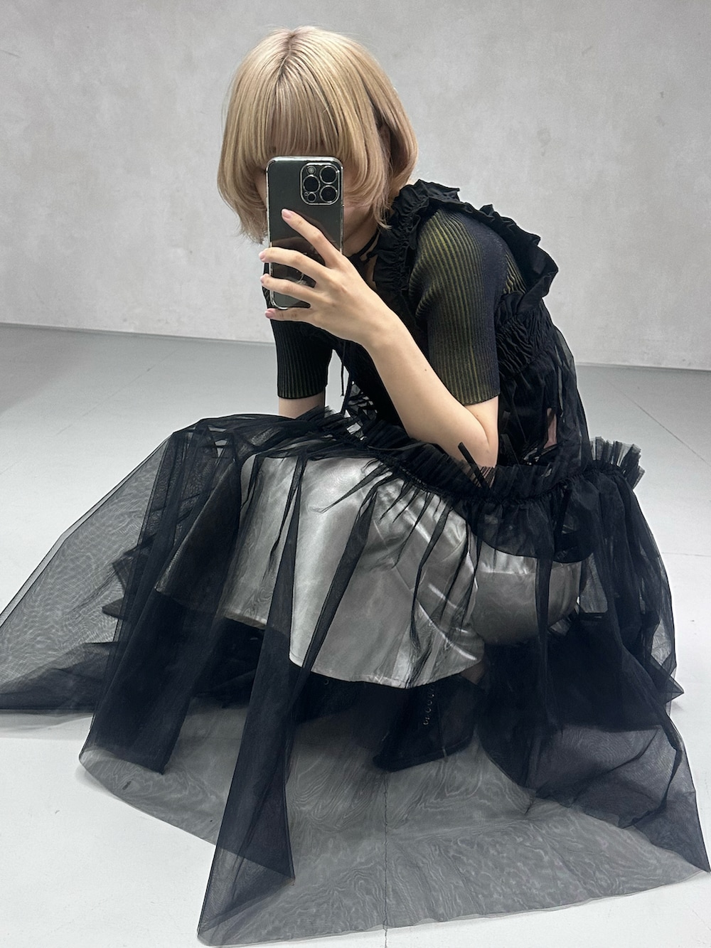 ブラック系のワンピース、ブラック系のパンプス、ブルー系のニット/セーターを着用したレディースの春コーディネートの4枚目の写真