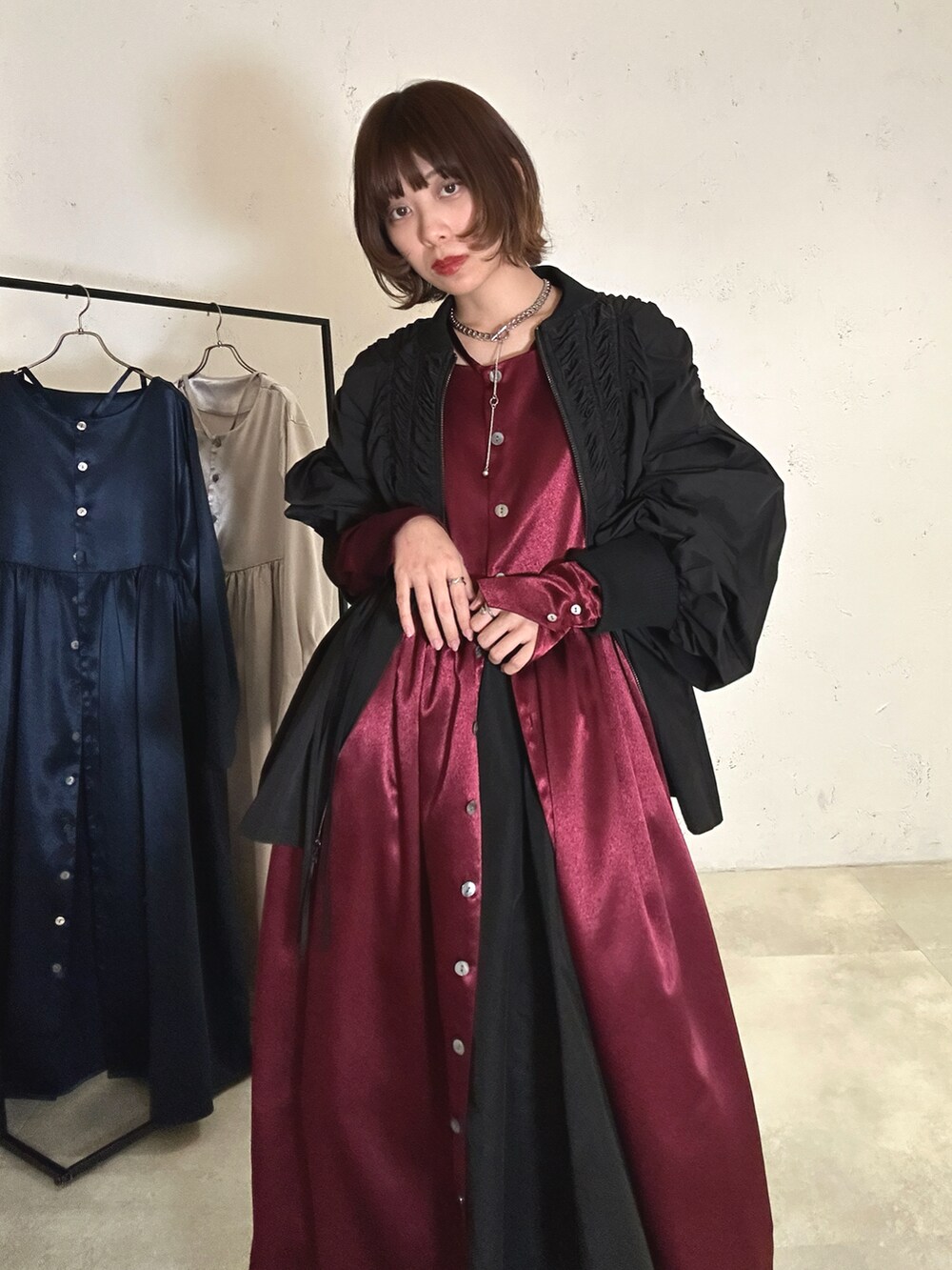 レッド系のワンピース、ブラック系のブルゾン、ブラック系のその他パンツを着用したレディースの冬コーディネートの2枚目の写真