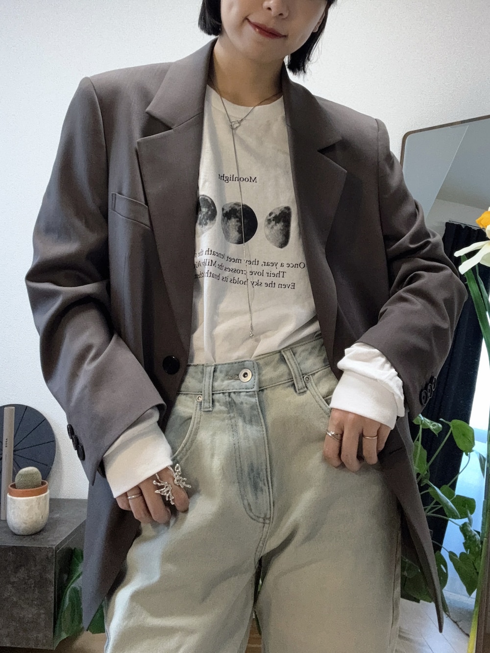 グレー系のテーラードジャケット、ブルー系のパンツ、ブラウン系のパンプスを着用したレディースの秋コーディネートの2枚目の写真