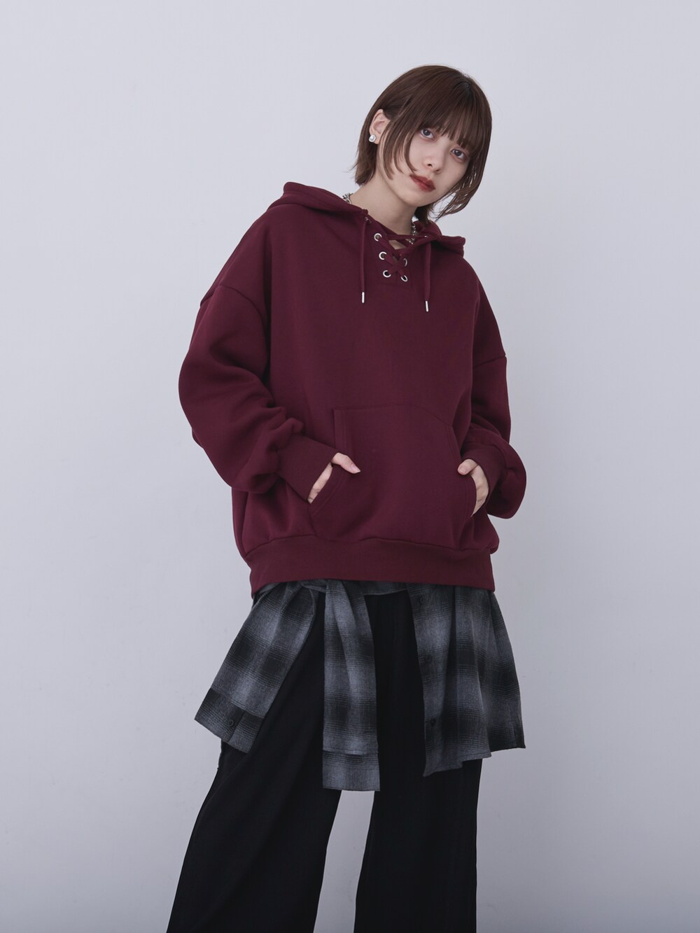 ブラック系のブルゾン、レッド系のパーカー、ブラック系のパンツを着用したレディースの冬コーディネートの3枚目の写真