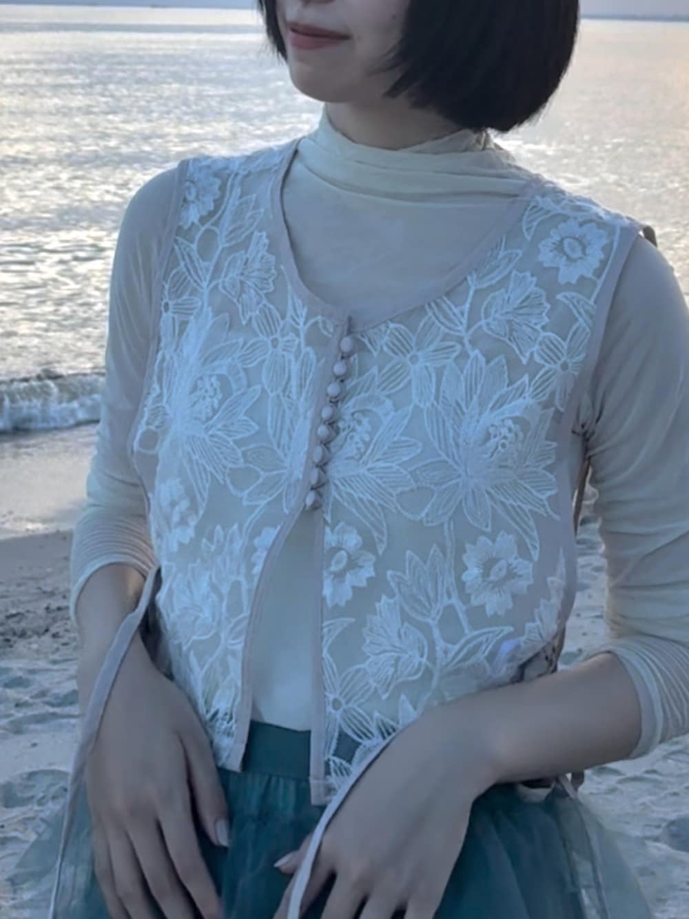 ブルー系のスカート、ブラック系のシューズ、ベージュ系のトップスを着用したレディースの夏コーディネートの3枚目の写真