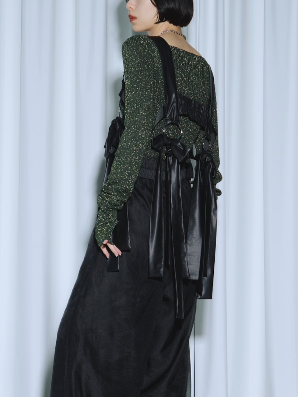 グリーン系のニット/セーター、ブラック系のテーラードジャケット、ブラック系のその他パンツを着用したレディースの春コーディネートの5枚目の写真