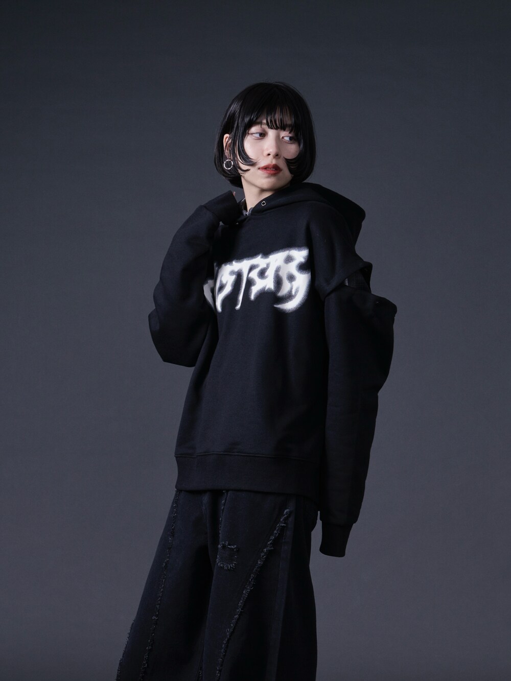 ブラック系のパーカー、ブラック系のデニムパンツを着用したレディースの冬コーディネートの5枚目の写真