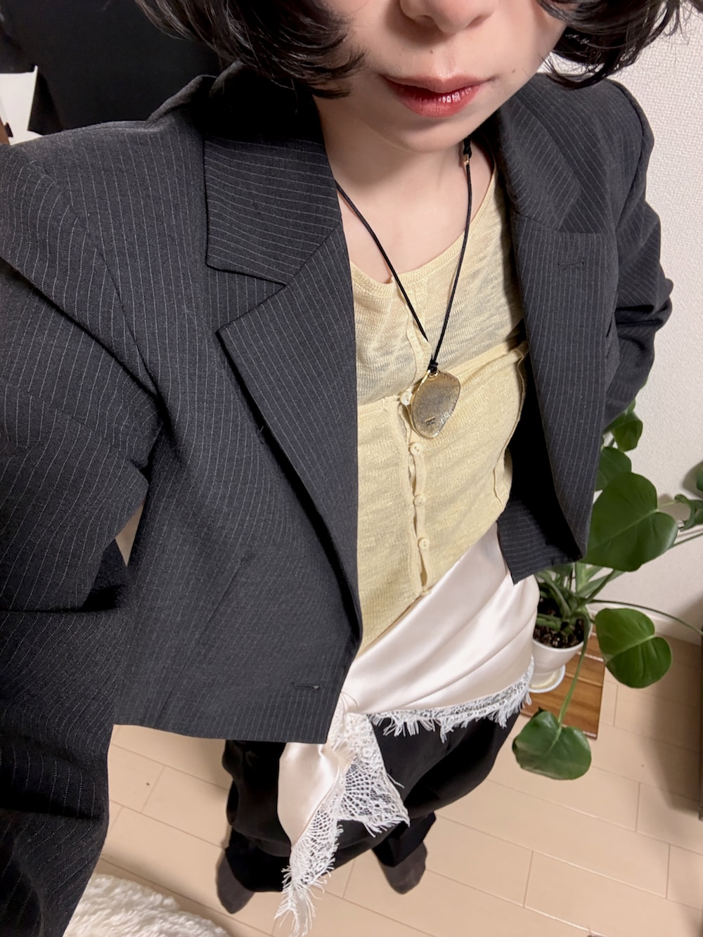 イエロー系のトップス、グレー系のジャケット/アウター、ブラック系のパンツを着用したレディースの春コーディネートの2枚目の写真