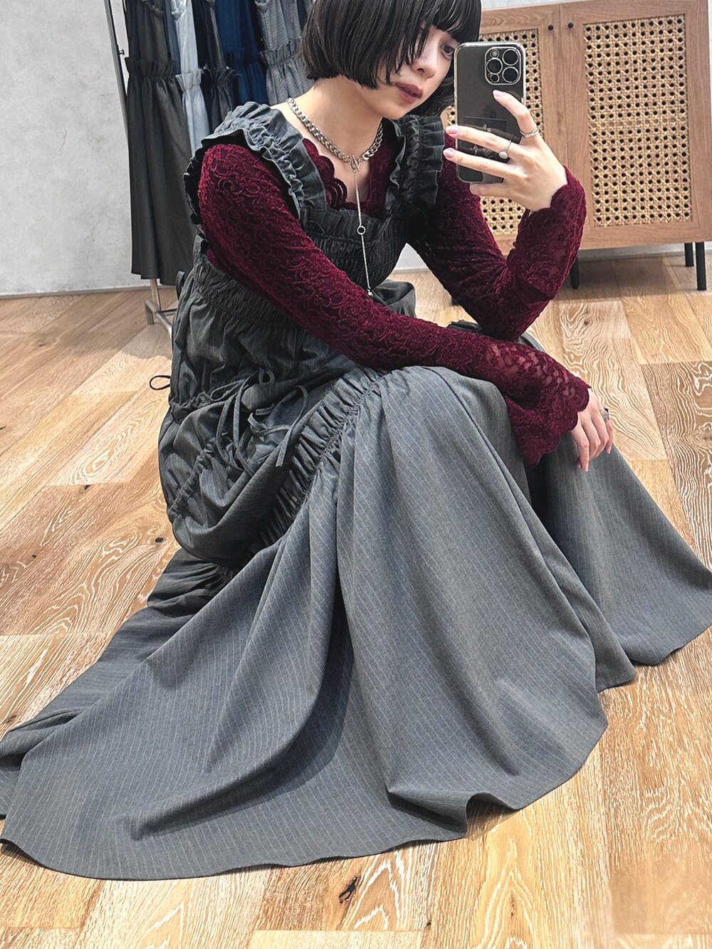 グレー系のワンピース/ドレス、レッド系のTシャツ/カットソー、ブラック系のブーツを着用したレディースの冬コーディネートの2枚目の写真