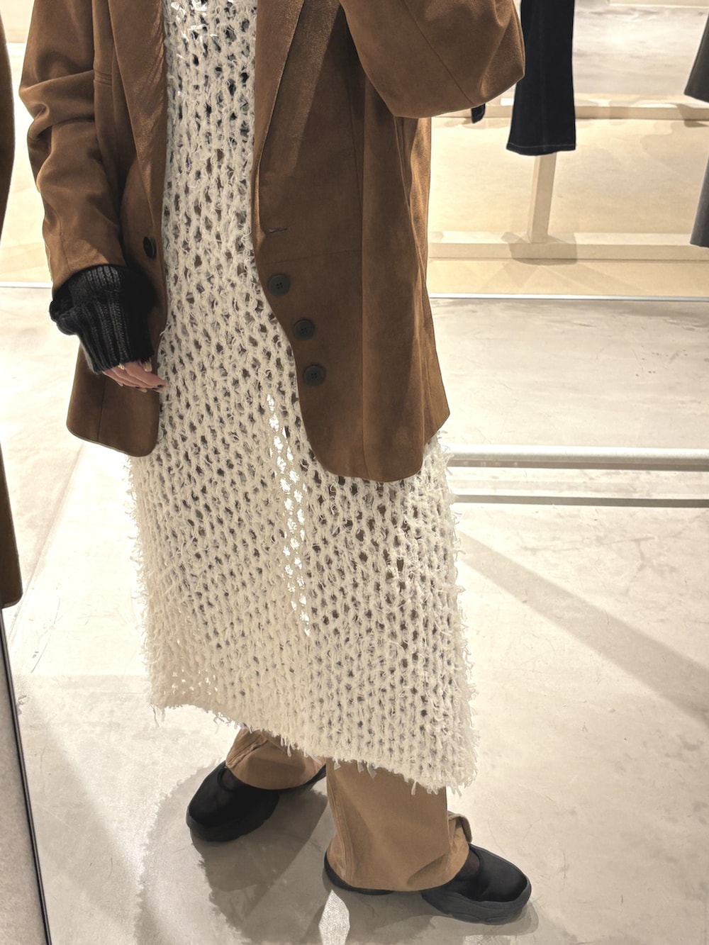 ブラウン系のテーラードジャケット、ブラウン系のデニムパンツ、ベージュ系のワンピース/ドレスを着用したレディースの冬コーディネートの3枚目の写真