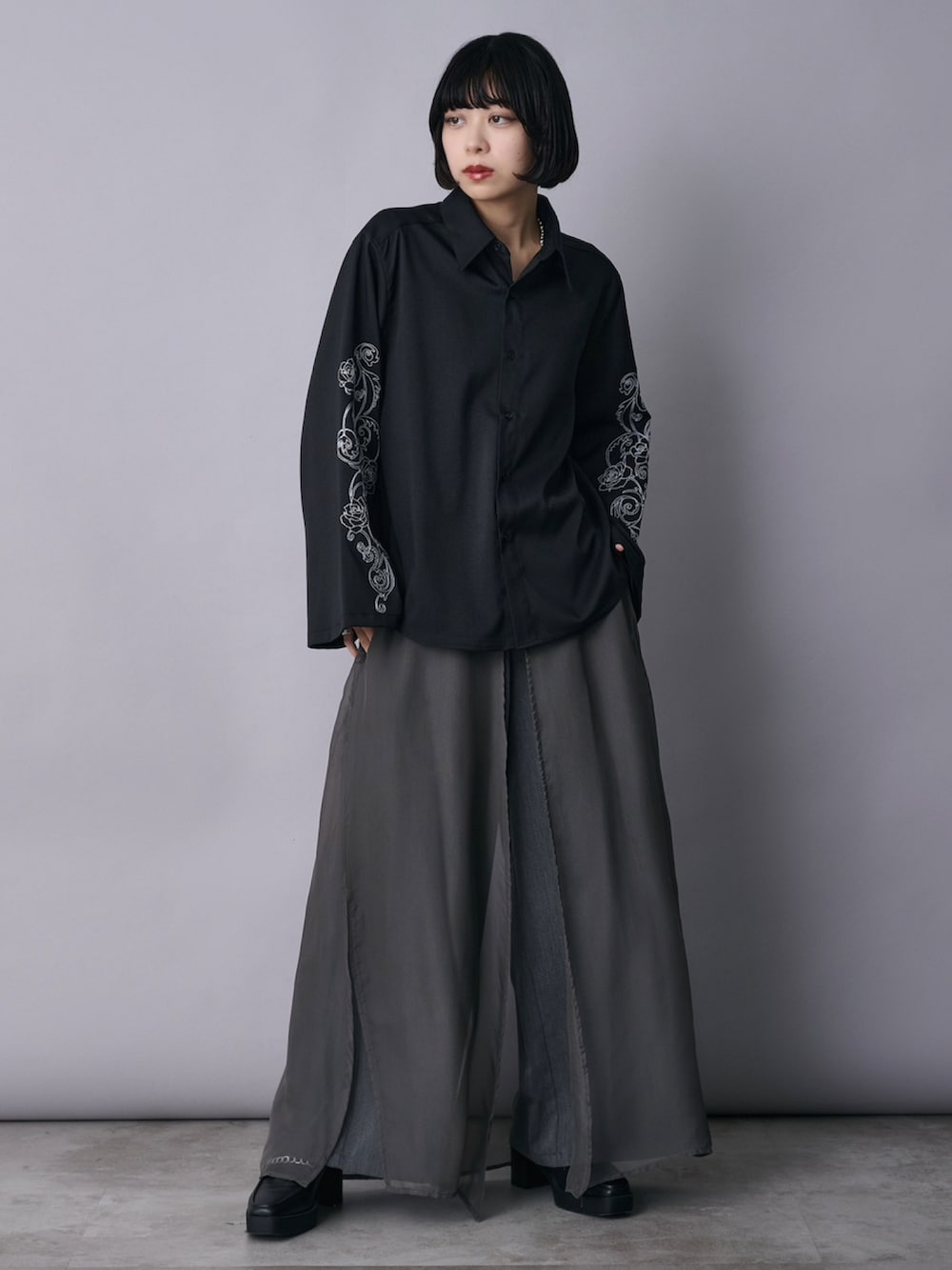 ブラック系のシャツ/ブラウス、グレー系のその他パンツ、ブラック系のローファーを着用したレディースの春コーディネートの2枚目の写真