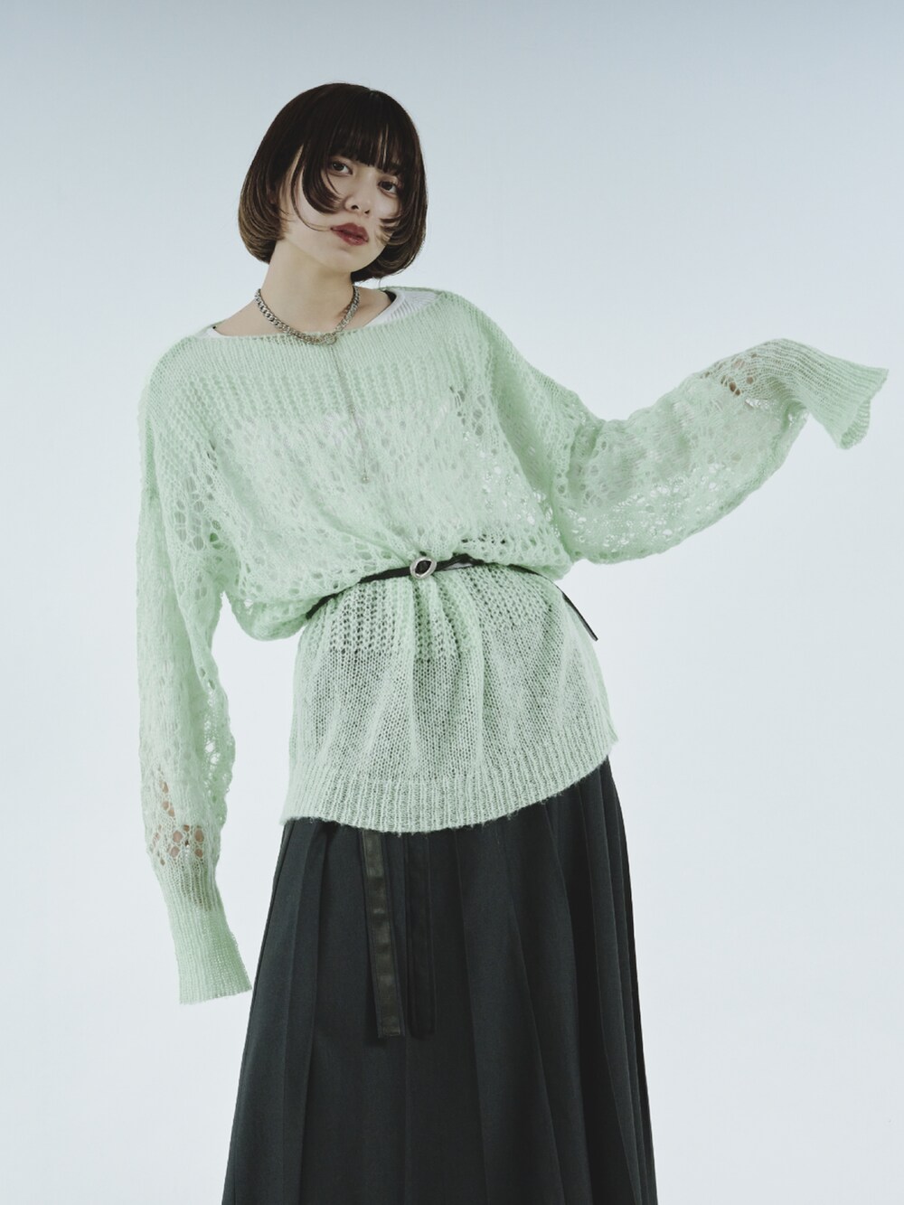 ブルー系のニット/セーター、グレー系のスカート、シルバー系のベルトを着用したレディースの冬コーディネートの3枚目の写真