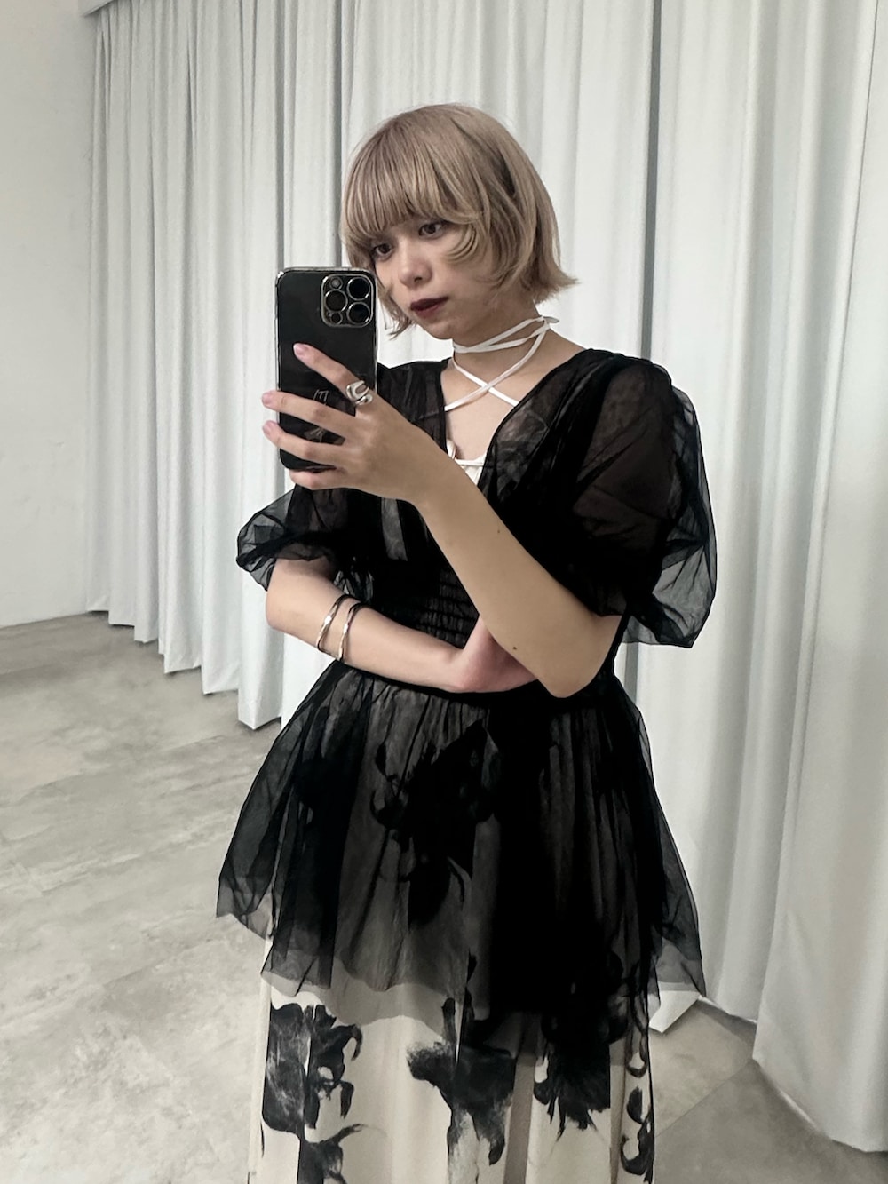 ホワイト系のワンピース、ブラック系のパンプス、ブラック系のトップスを着用したレディースの春コーディネートの3枚目の写真