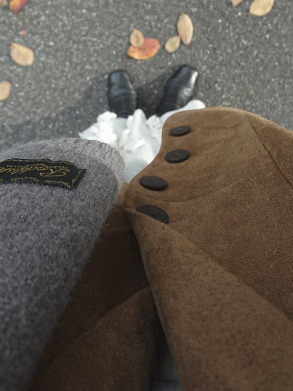 ブラウン系のテーラードジャケット、ホワイト系のトップス、ブラック系のショルダーバッグを着用したレディースの冬コーディネートの3枚目の写真