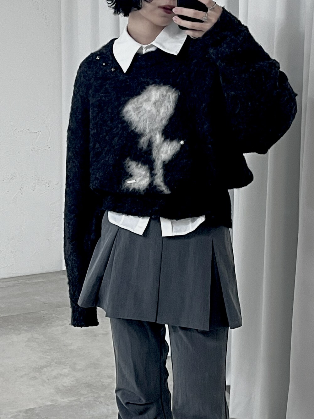 グレー系のニット/セーター、グレー系のスラックス、ブラック系のブーツを着用したレディースの冬コーディネートの2枚目の写真