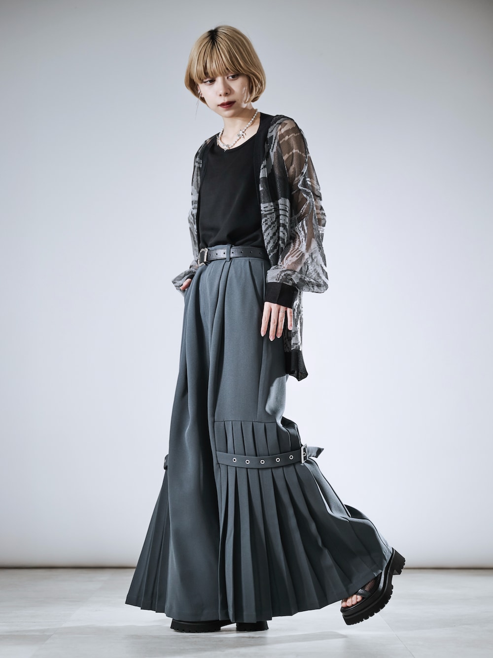 グレー系のその他パンツ、ブラック系のカーディガン/ボレロ、シルバー系のネックレスを着用したレディースの春コーディネートの3枚目の写真