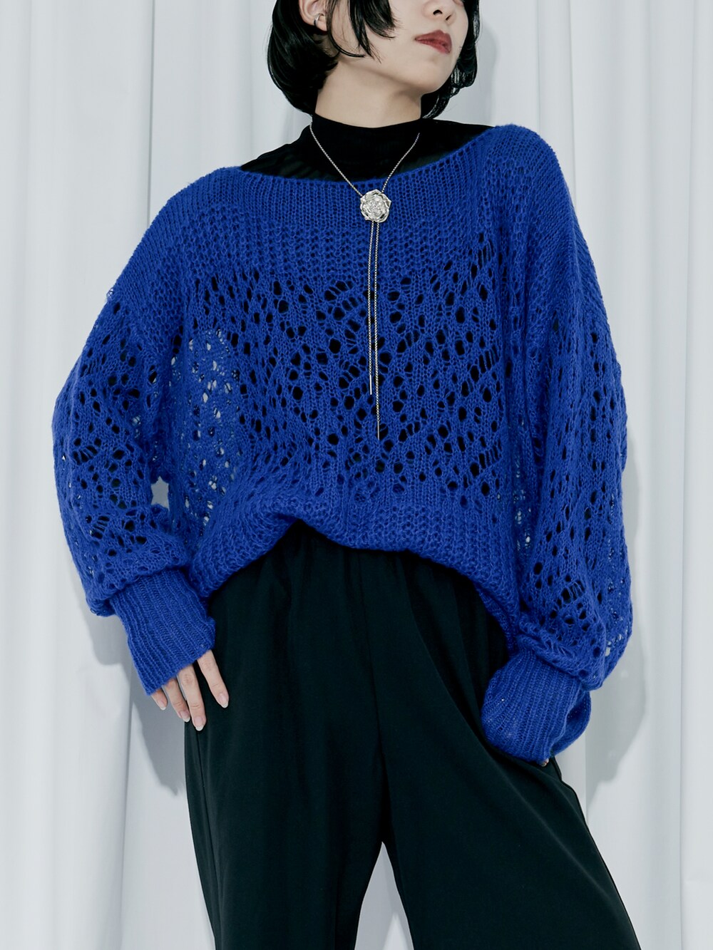 ブルー系のニット/セーター、ブラック系のスラックス、ブラック系のパンプスを着用したレディースの冬コーディネートの2枚目の写真