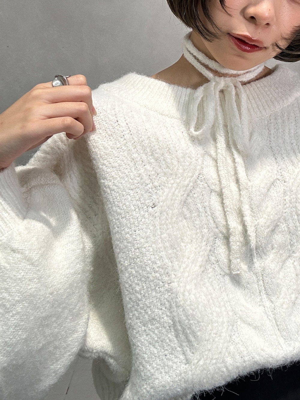 ブラック系のブーツ、ホワイト系のニット/セーター、ホワイト系のその他を着用したレディースの冬コーディネートの2枚目の写真