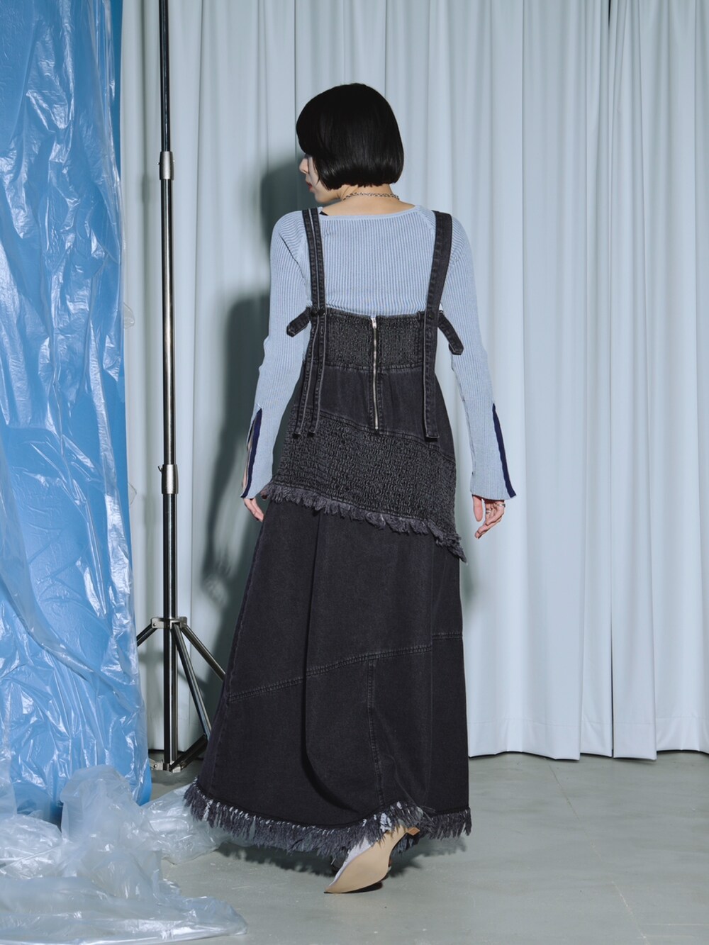 ブラック系のワンピース、ブルー系のニット/セーター、シルバー系のパンプスを着用したレディースの春コーディネートの3枚目の写真