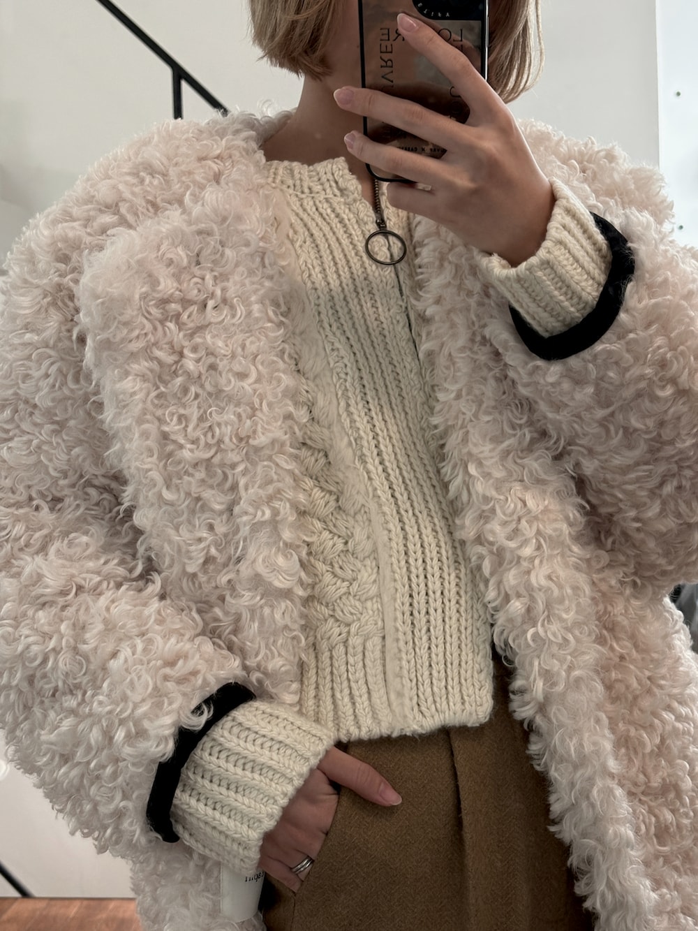 ベージュ系のニット/セーター、ブラウン系のパンツ、ホワイト系のジャケット/アウターを着用したレディースの春コーディネートの2枚目の写真