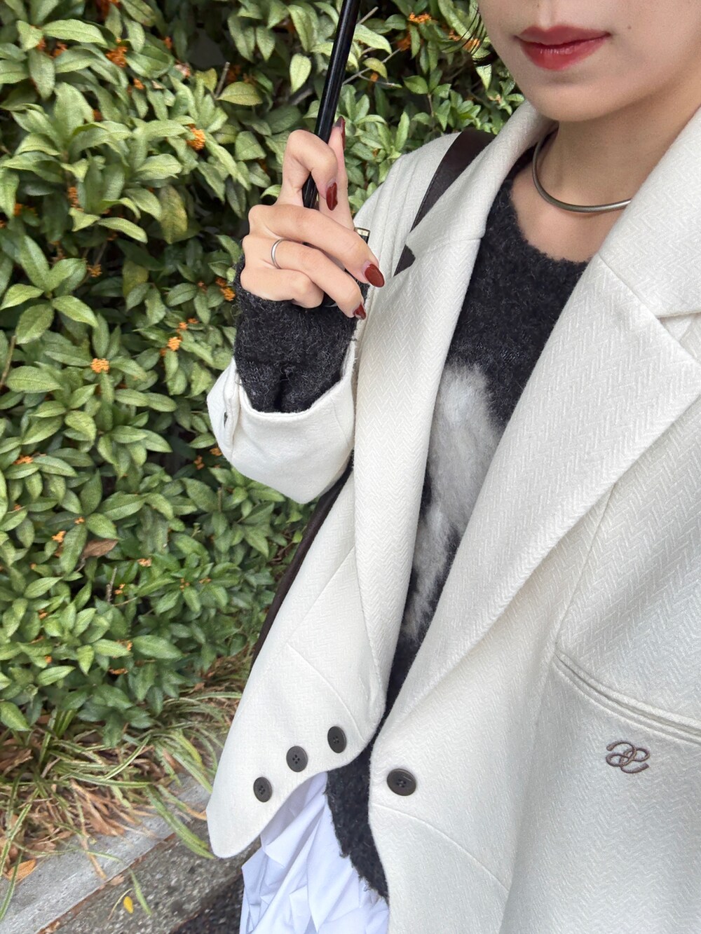 ホワイト系のスカート、グレー系のニット/セーター、ホワイト系のジャケット/アウターを着用したレディースの秋コーディネートの3枚目の写真