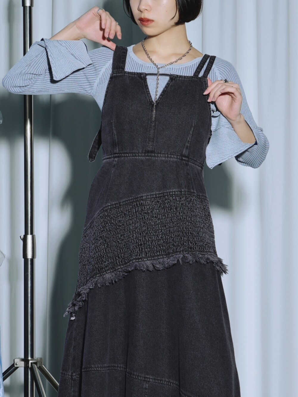 ブラック系のワンピース、ブルー系のニット/セーター、シルバー系のパンプスを着用したレディースの春コーディネートの4枚目の写真