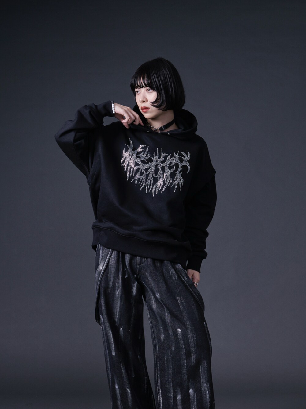 ブラック系のパーカー、ブラック系のデニムパンツ、ブラック系のローファーを着用したレディースの冬コーディネートの3枚目の写真