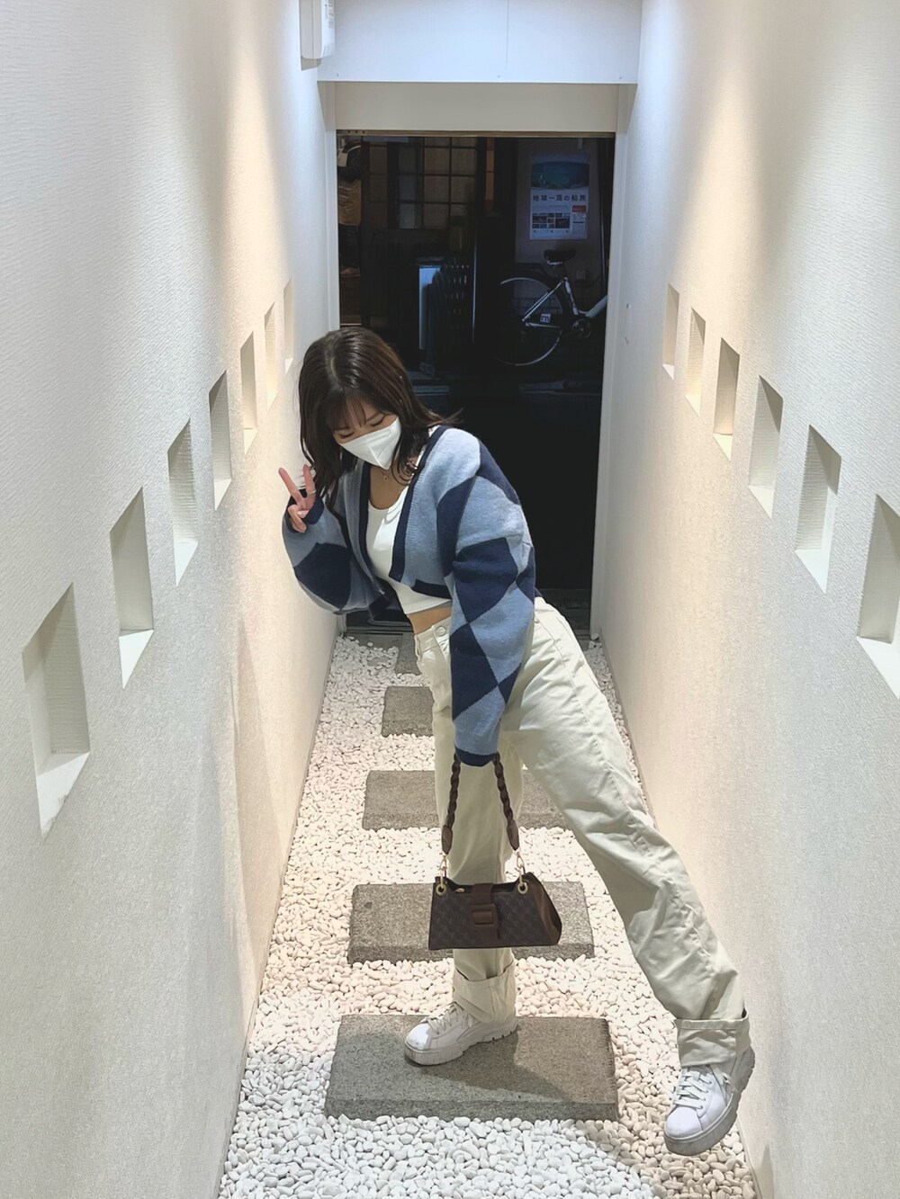 ブルー系のカーディガン/ボレロ、ホワイト系のトップス、ベージュ系のデニムパンツを着用したレディースの冬コーディネートの2枚目の写真