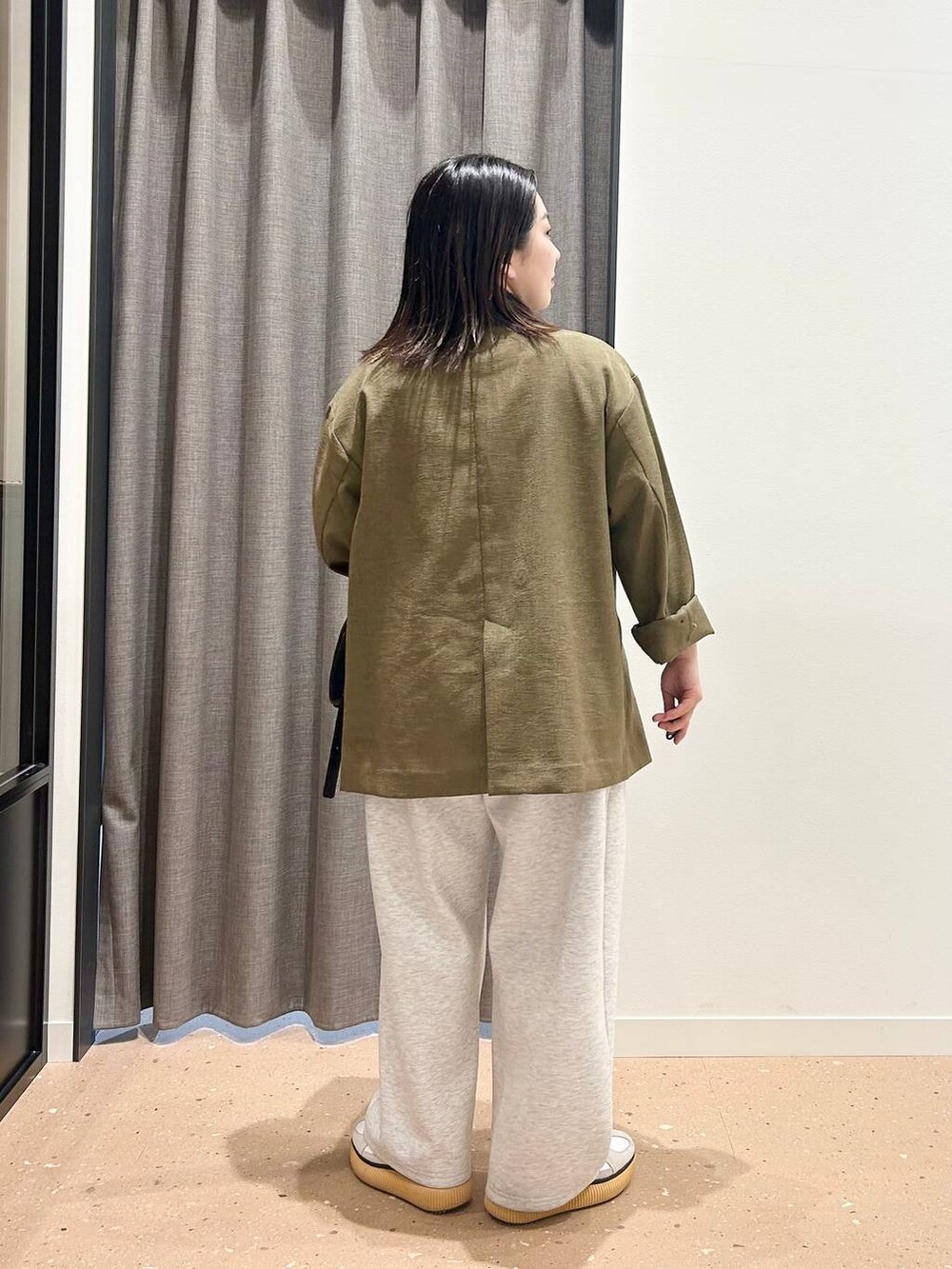 ブラウン系のテーラードジャケット、ホワイト系のTシャツ/カットソー、ブラック系のトートバッグを着用したレディースの春コーディネートの2枚目の写真