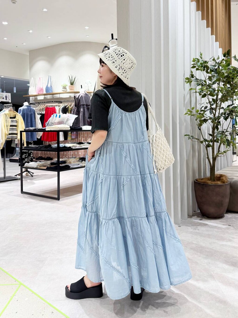 ブラック系のサンダル、ホワイト系のトートバッグ、ブルー系のワンピースを着用したレディースの春コーディネートの3枚目の写真