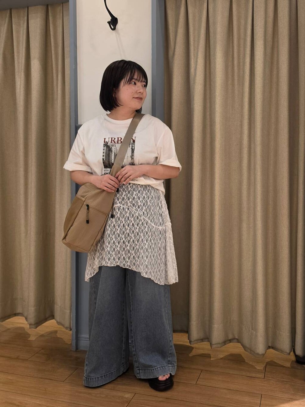 ベージュ系のショルダーバッグ、ホワイト系のスカート、ブルー系のデニムパンツを着用したレディースの夏コーディネートの2枚目の写真