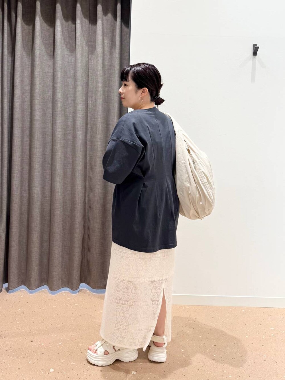 ホワイト系のサンダル、ベージュ系のトートバッグ、ホワイト系のスカートを着用したレディースの春コーディネートの2枚目の写真