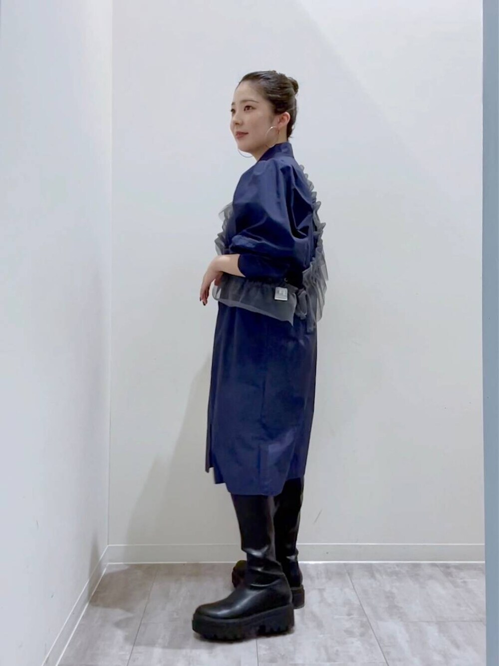 ブルー系のシャツ/ブラウス、ホワイト系のショルダーバッグ、ブラック系のブーツを着用したレディースの秋コーディネートの2枚目の写真