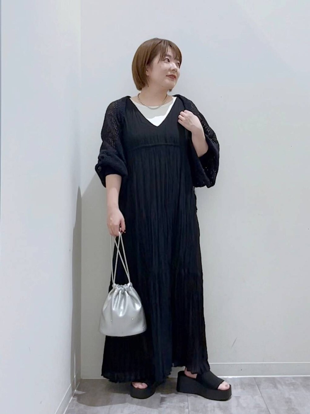 ブラック系のサンダル、シルバー系のショルダーバッグ、ホワイト系のタンクトップを着用したレディースの夏コーディネートの3枚目の写真