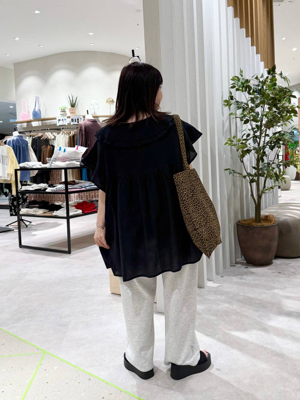 ブラック系のサンダル、その他のトートバッグ、グレー系のデニムパンツを着用したレディースの春コーディネートの4枚目の写真