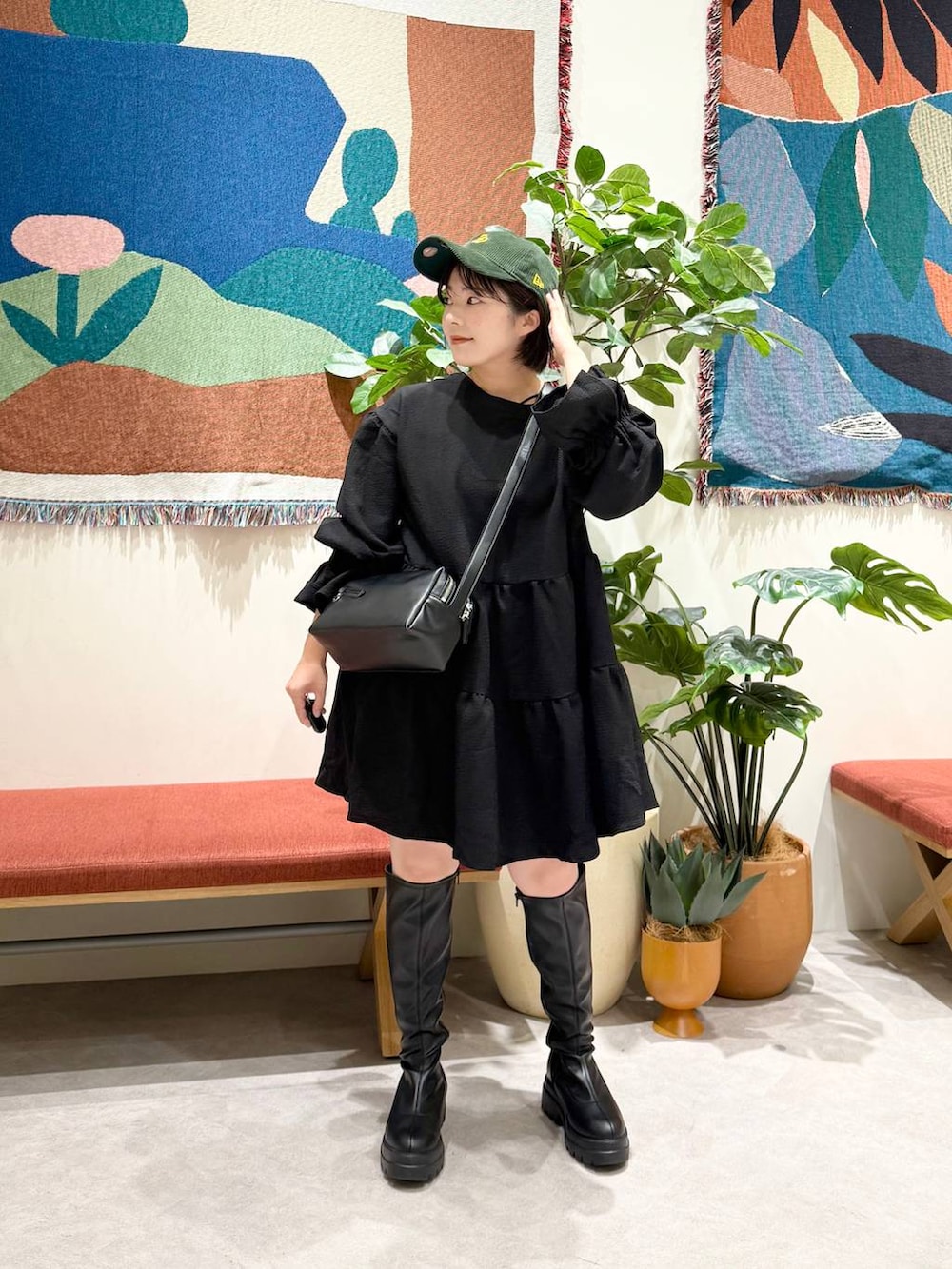 ブラック系のショルダーバッグ、ブラック系のブーツ、ブラック系のワンピースを着用したレディースの秋コーディネートの5枚目の写真