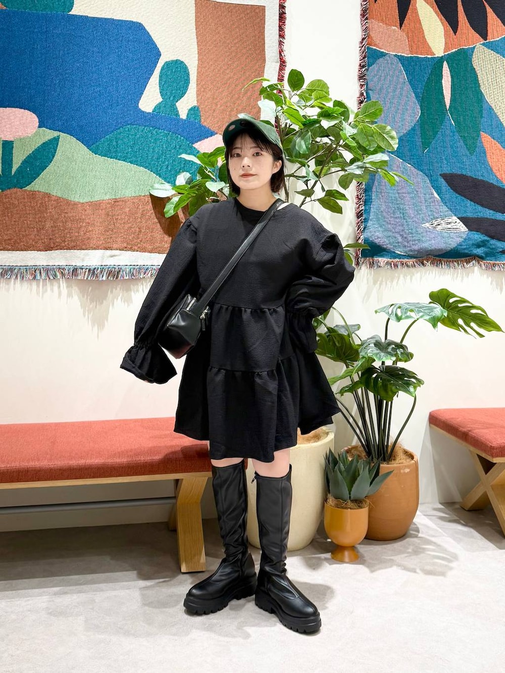 ブラック系のショルダーバッグ、ブラック系のブーツ、ブラック系のワンピースを着用したレディースの秋コーディネートの2枚目の写真