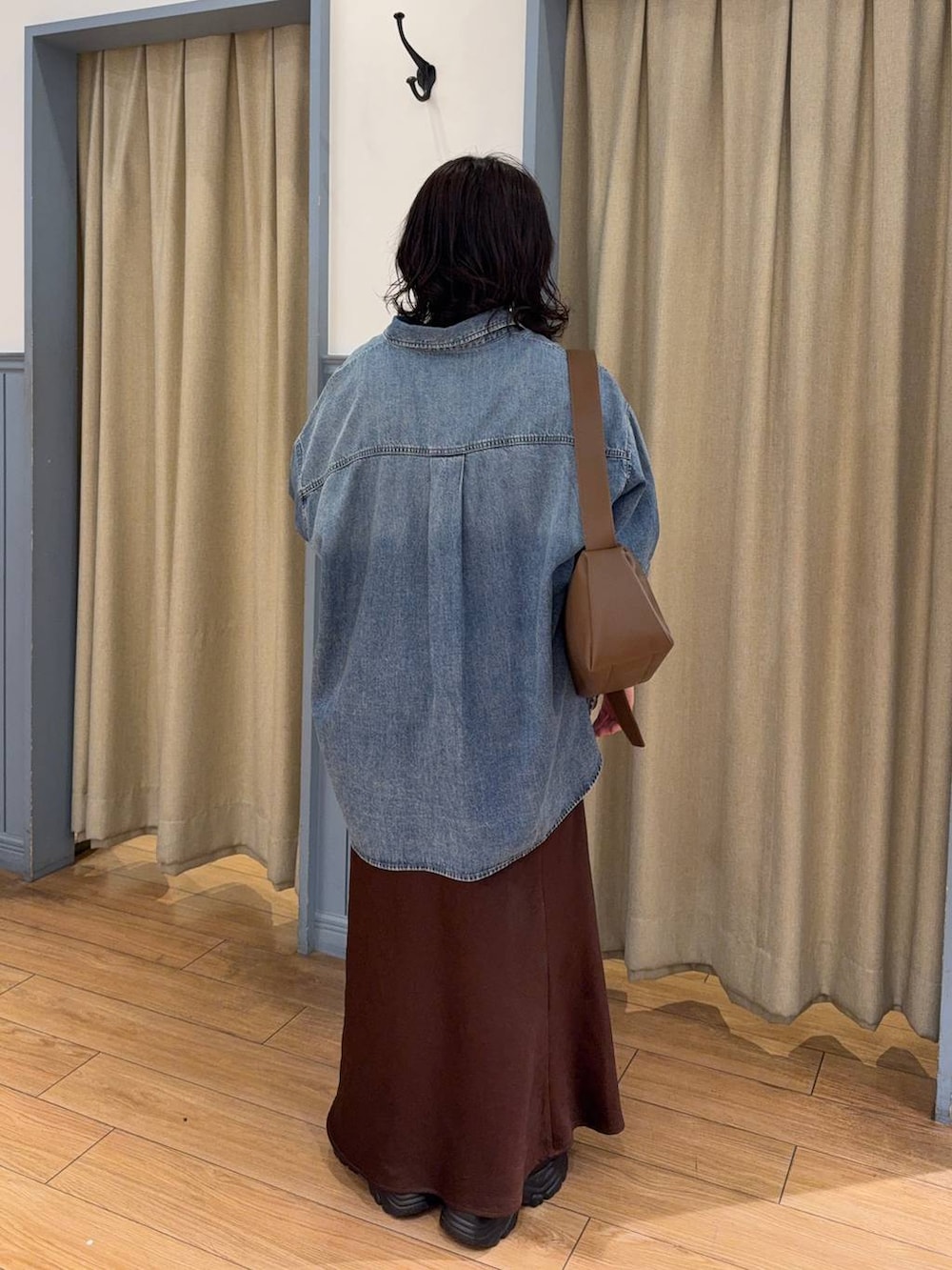 ブラウン系のスカート、ブラック系のローファー、ブルー系のシャツ/ブラウスを着用したレディースの春コーディネートの2枚目の写真