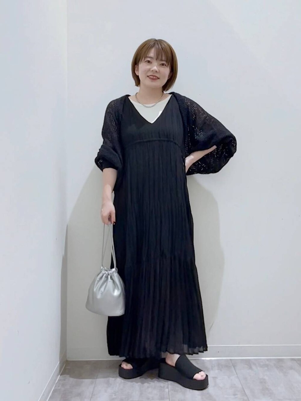 ブラック系のサンダル、シルバー系のショルダーバッグ、ホワイト系のタンクトップを着用したレディースの夏コーディネートの4枚目の写真