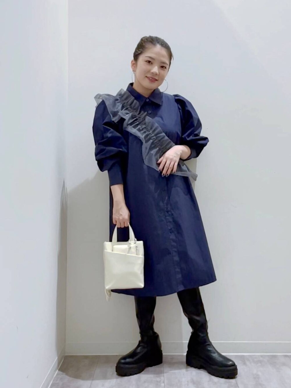 ブルー系のシャツ/ブラウス、ホワイト系のショルダーバッグ、ブラック系のブーツを着用したレディースの秋コーディネートの4枚目の写真