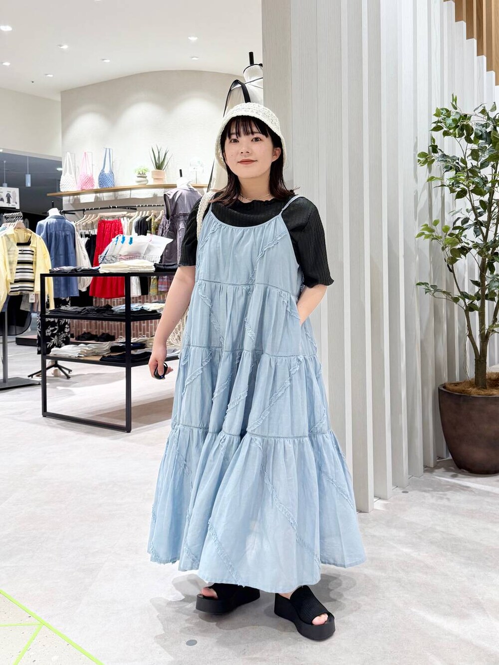 ブラック系のサンダル、ホワイト系のトートバッグ、ブルー系のワンピースを着用したレディースの春コーディネートの2枚目の写真